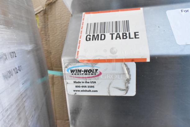 Win-Holt stainless steel counter with two doors and shelf, commercial casters. Labels show "GMD Table" and "Made in the USA."