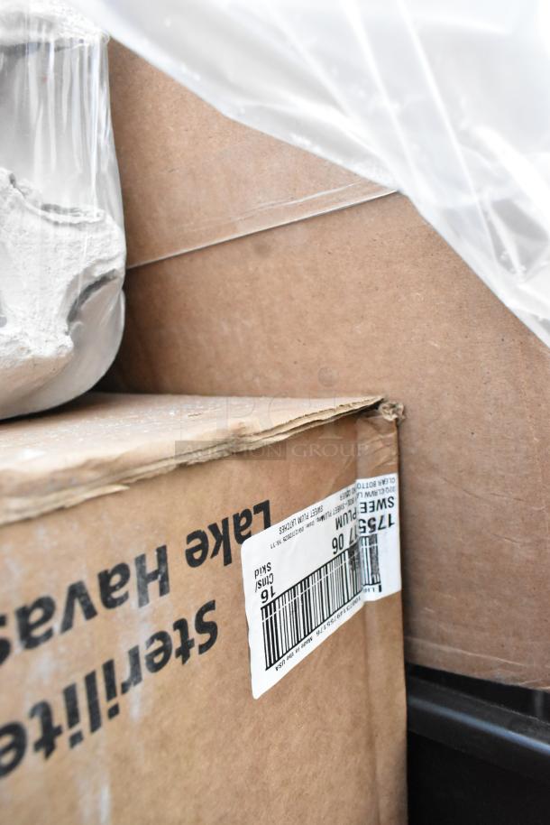 Cardboard boxes with visible labels, part of 15 brand new scratch and dent items including paper towels and containers.