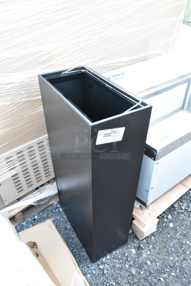 Brand new Lancaster Table & Seating black trash can with minor scratches, shown outdoors with a label "392 QTY 1".