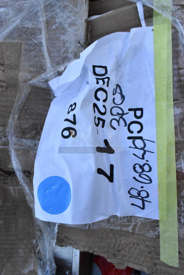 Label on cardboard with text "DEC25-17," numbers, and symbols, partially obscured by plastic wrap.