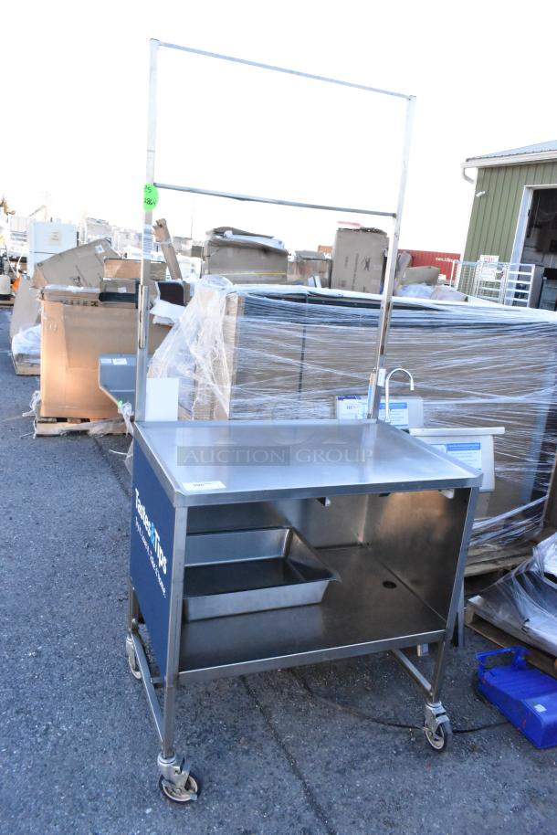 Stainless steel table with under shelf, drawer, and commercial casters. Features a tall frame. Good condition.