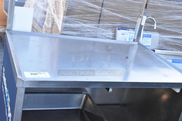 Stainless steel table with under shelf, drawer, and commercial casters, in good condition. Auction tag indicates lot number 396.
