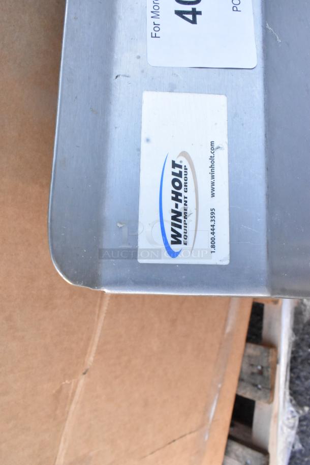 Winholt stainless steel 3-bay sink with dual drain boards, visible branding label, no legs included.