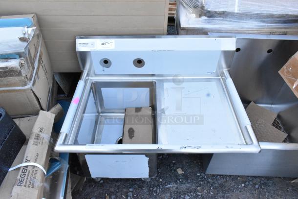 Brand new Regency 600S1162018R stainless steel single bay sink with right side drain board, light scratches and dents visible.