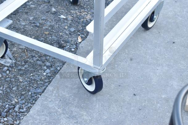 Metal commercial pan transport rack on casters, sturdy frame, ideal for kitchen use, slight wear visible.