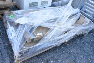 Pallet with four new items, including a portable stage and traffic door, wrapped in plastic with visible labels.