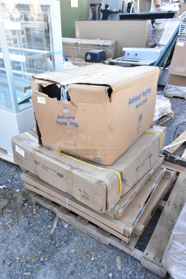 Five new scratch and dent items, including Ashland grease trap (Part# 4935) and tabletops, in damaged boxes.