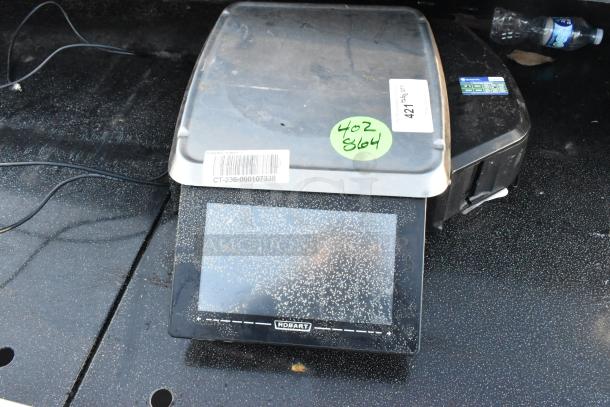 Hobart HTi-LH countertop scale with touchscreen. Visible labels include a barcode and lot number. Good condition.