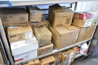 Alt text: Boxes of Rubbermaid Auto Foam refills, Aqua Sparkle detergent, Dymo label printer on metal shelves. Various brands visible.