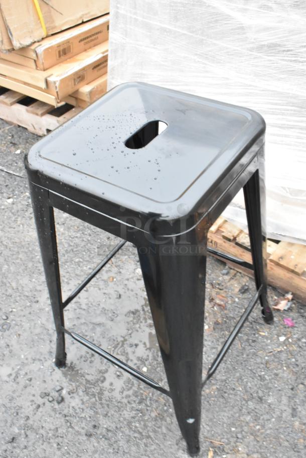 New Lancaster 164CMBKLSBLK Alloy Onyx Black backless counter stool in outdoor setting, minor scratches visible.