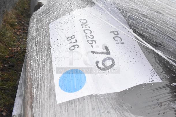 Plastic-wrapped auction items labeled "DEC25-79", showing droplets, indicating a lot of 23 new scratch and dent items.