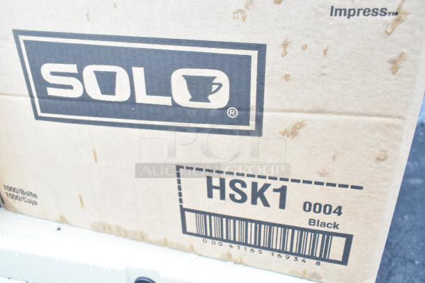 Cardboard box labeled "SOLO" with "HSK1 0004 Black" and barcode, contains bakery bread trays, teaspoons, ramekin cups.