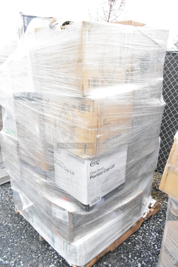 A pallet of brand new scratch and dent items including paper towels, plastic plates, deli containers, and portion cups, wrapped in plastic.
