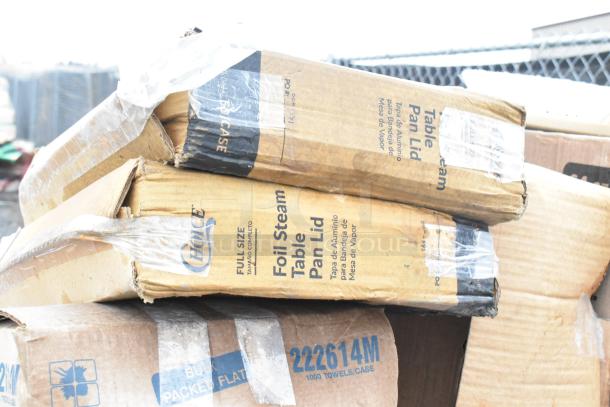 Cardboard boxes labeled "Foil Steam Table Pan Lid" and "1000 Towels/Case," showing signs of wear and scratches.