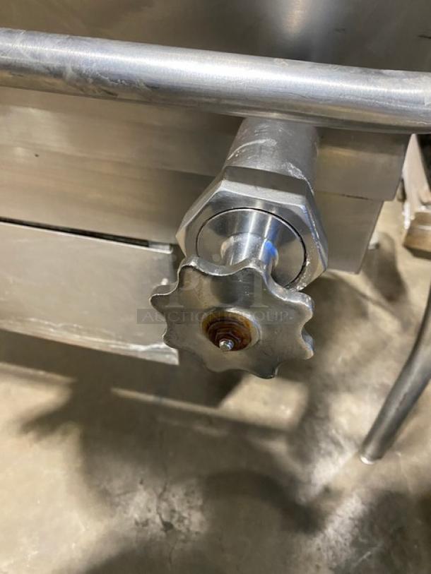 Cleveland Range stainless steel gas-powered tilted braising pan handle. Shiny condition, mounted on sturdy legs.