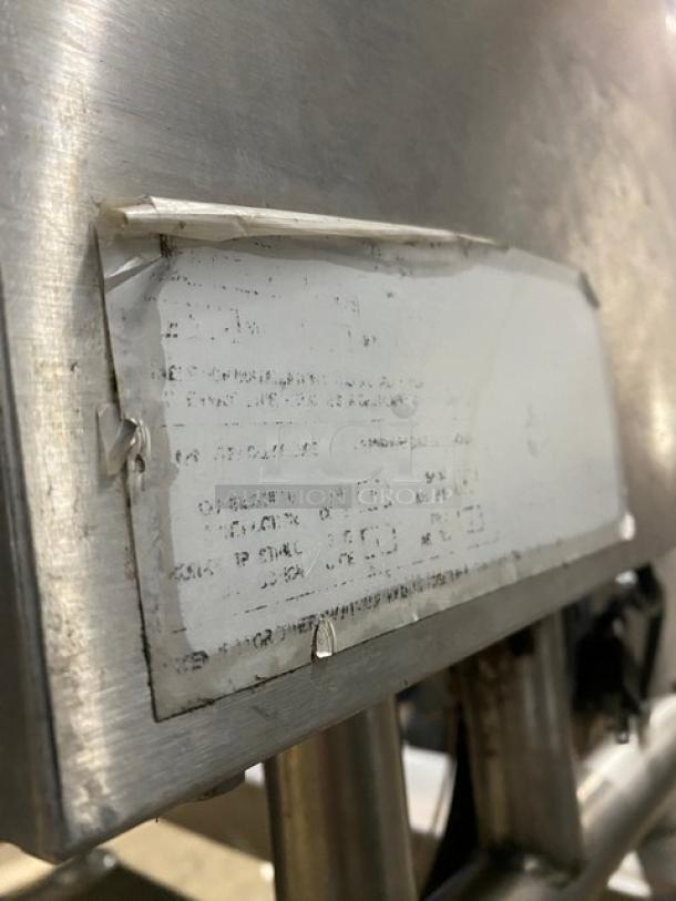 Cleveland Range stainless steel gas-powered tilted braising pan, visible wear on labeling, mounted on sturdy legs.