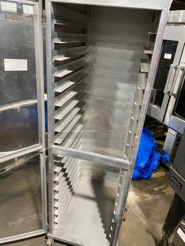 Commercial heavy-duty enclosed pan holding/transport rack on casters, metal construction, multiple shelf slots, used condition.