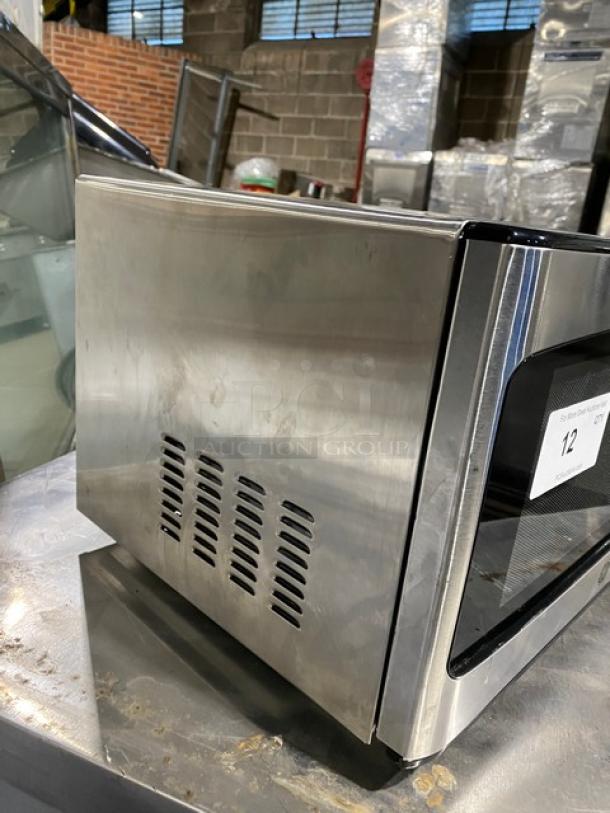 Stainless steel GE JES1145SH1SS countertop microwave, 2018 model, electric powered, with visible venting on the side.