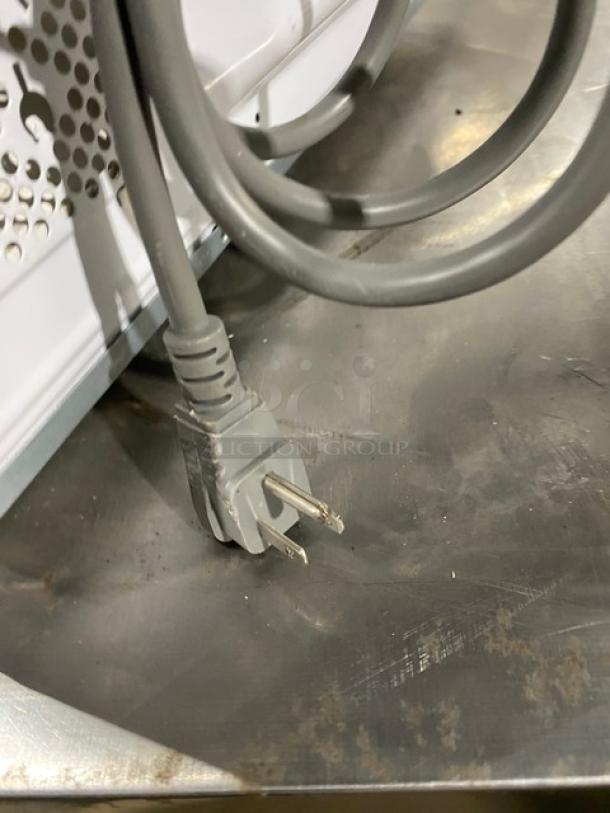 GE Appliances 2018 model JES1145SH1SS countertop microwave plug on metal surface, commercial-grade, stainless steel.