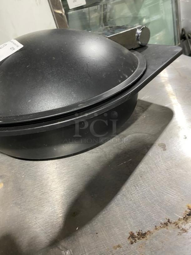 Spring USA induction chafing dish with chrome handle, black finish, round shape, slightly worn, ideal for commercial use.