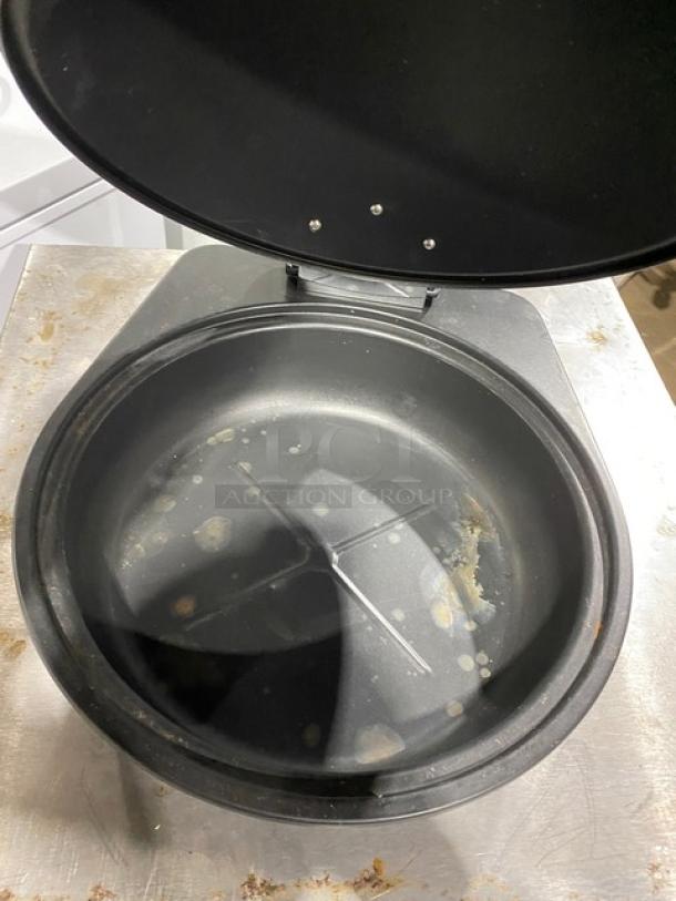 Spring USA induction chafing dish with chrome handle. Features visible wear inside, highlighting commercial use.