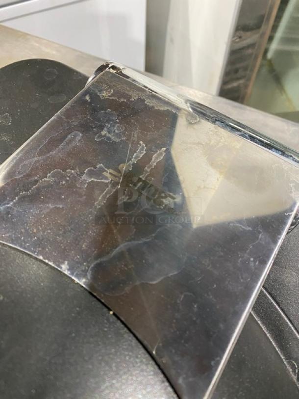 Spring USA induction chafing dish with chrome handle, surface wear visible, featuring "Spring" engraving on cover.