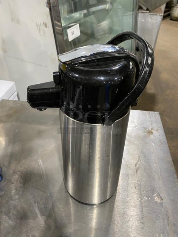 Commercial stainless steel insulated beverage dispenser, black lid and handle, used condition, ideal for catering.