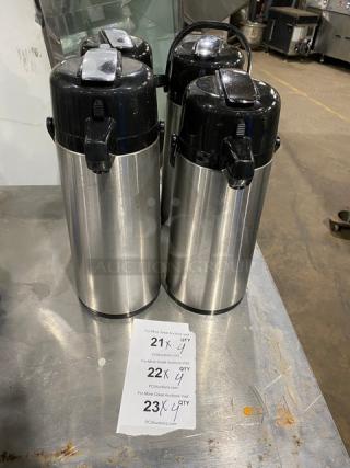 Commercial stainless steel insulated beverage dispensers, black lids, excellent condition, lot of four, auction labels visible.