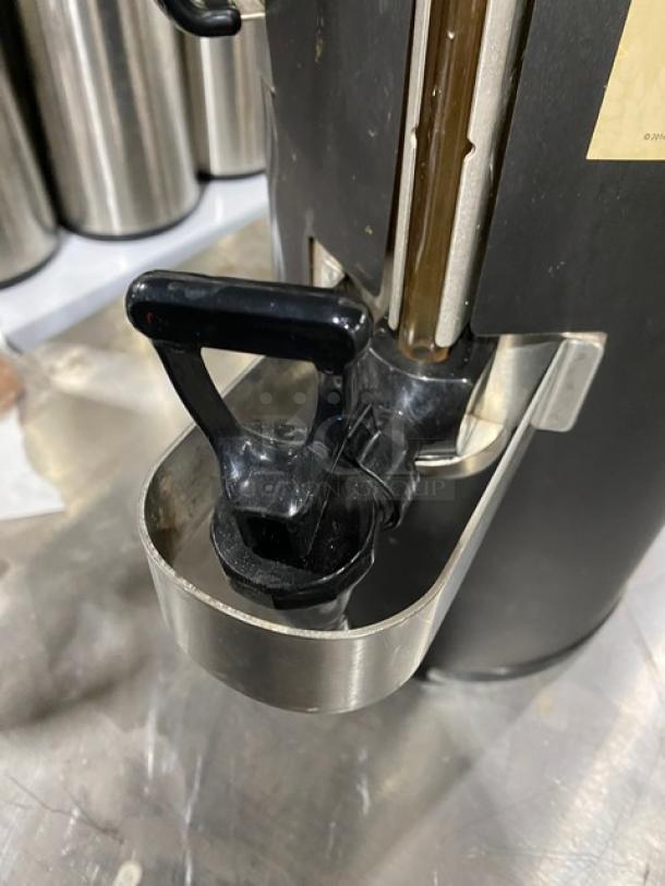 Fetco Starbucks-style black insulated beverage dispenser with spout and handle. Commercial use, good condition.