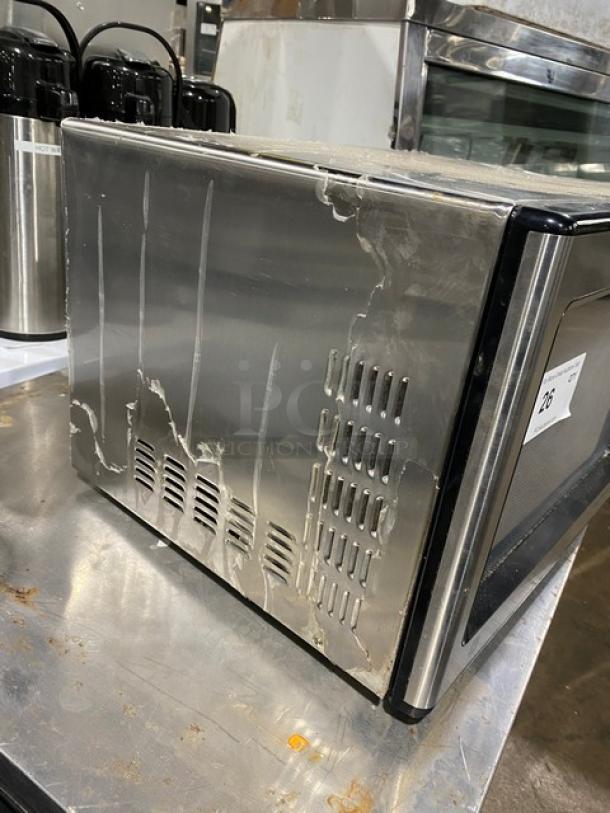 GE JES1651SJ02 stainless steel countertop microwave, 2009 model. Visible wear on sides, serial number RS903160U.