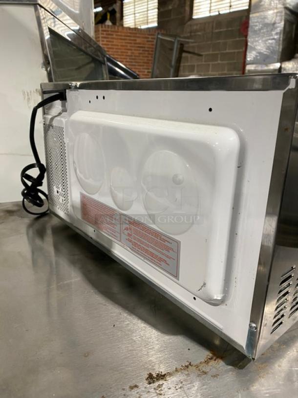 GE Appliances 2010 JES1142SJ06 commercial countertop microwave, stainless steel, electric-powered, rear view with vents.