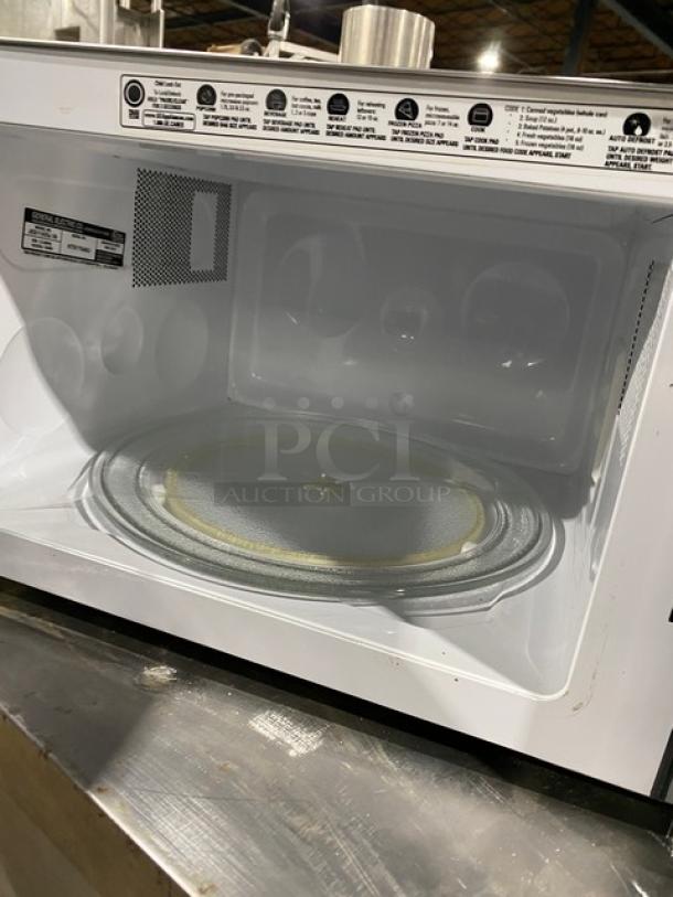 GE JES1142SJ06 stainless steel commercial microwave, 2010 model. Interior and control panel visible. Serial: HT917648U.