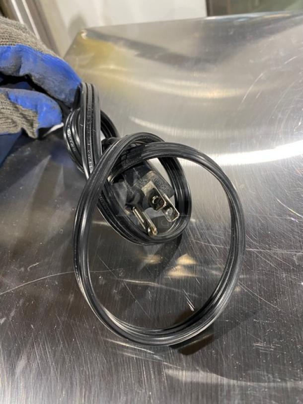 Power cord of GE Appliances commercial stainless steel microwave, Model JES1142SJ06, 2010, visible on countertop.