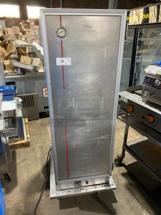 Commercial stainless steel electric insulated heating/proofing cabinet with built-in pan racks, on casters, with temperature gauge.