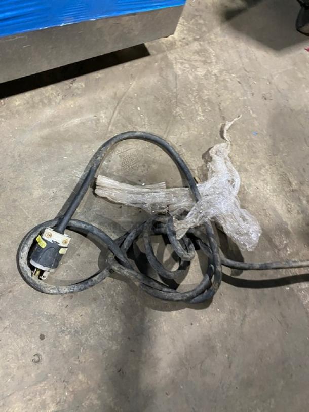 A tangled power cord for a commercial stainless steel heating/proofing cabinet with built-in pan holding racks is shown.