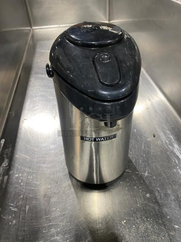 Commercial stainless steel insulated beverage dispenser, labeled "Hot Water," with black lid. Used condition.