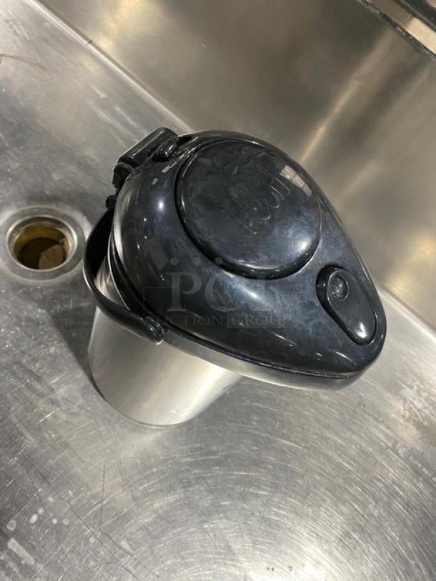 Commercial stainless steel insulated beverage dispenser with black lid, good condition, ideal for hot or cold drinks.