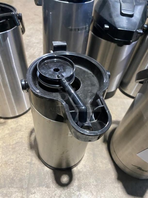 Stainless steel insulated beverage dispenser with black lid and spout, in good condition, ideal for commercial use.