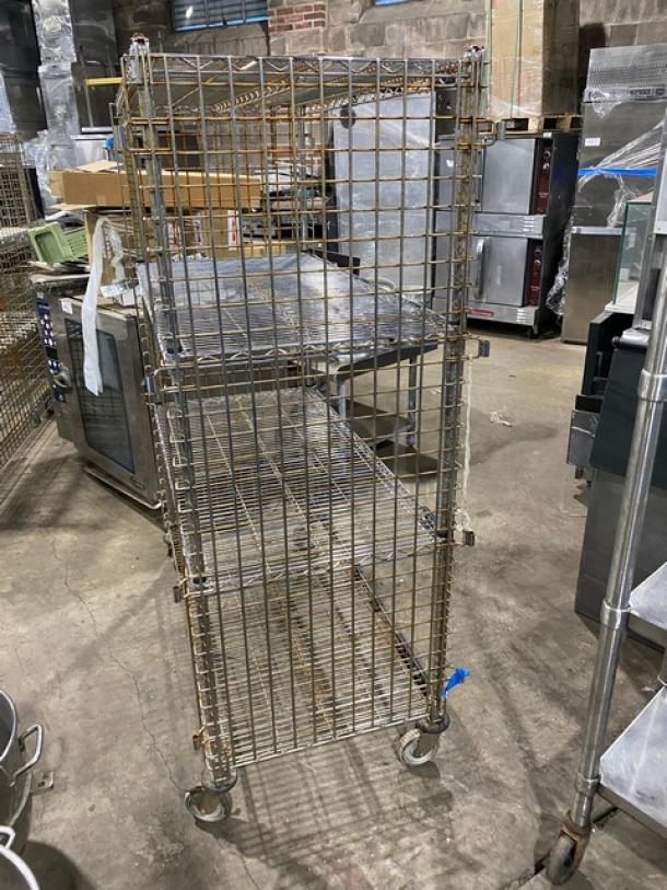 Commercial 4-tier mobile enclosed wired-rack utility cart, durable metal, on casters, visible wear, ideal for storage.