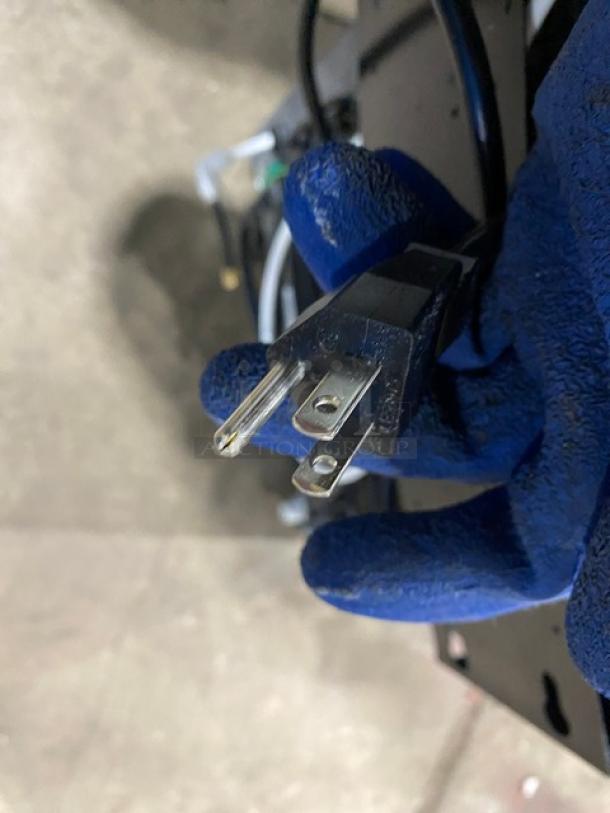 Alpine EcoStream 3001 water dispenser plug, model 3001, SN: 16060358, 120V, 1-phase, shown held with blue glove.