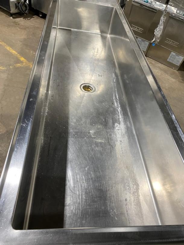 Commercial stainless steel single-well ice bin with right side drain board, on legs. Extra-large, showing light wear.