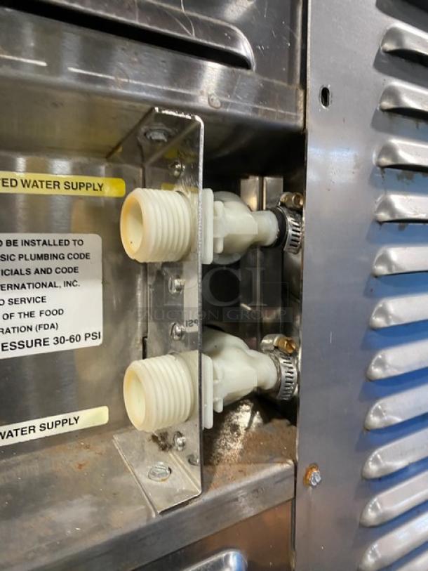 Groen C220E stainless steel convection steamer oven, showing water supply connections and caution label.