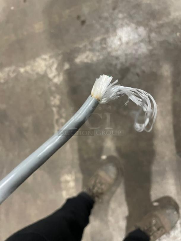 Frayed end of a gray power cable for a Hoshizaki DCM-500BAF ice/water dispenser. Cable shows wear and internal fibers.