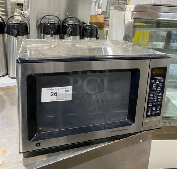 GE JES1651SJ02 stainless steel countertop microwave, circa 2009, electric powered, good condition, auction tag visible.