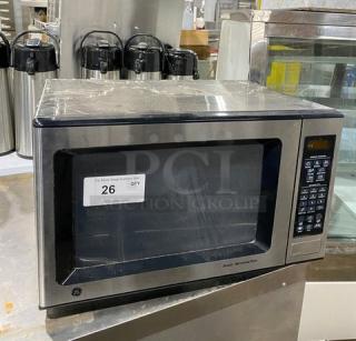 GE JES1651SJ02 stainless steel countertop microwave, circa 2009, electric powered, good condition, auction tag visible.
