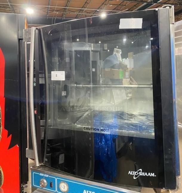 Alto-Shaam commercial stainless steel electric rotisserie oven with digital controls, used. Door marked "Caution Hot!".