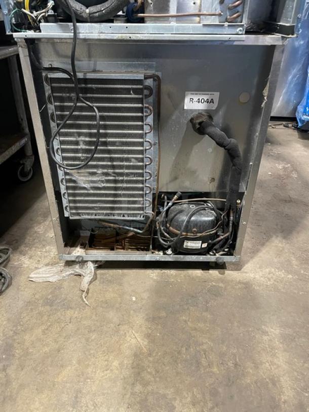 Delfield Model 406CA undercounter fridge, stainless steel, poly coated rack, on casters, R-404A label visible.