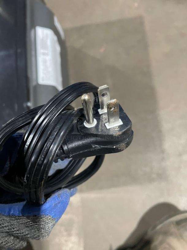 LG LCS1112ST countertop microwave power cord, coiled neatly. Plug shows standard three prongs for 120V use.