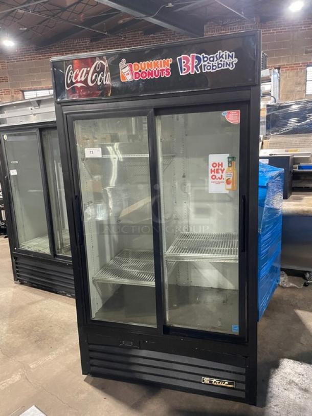 True commercial black double glass sliding door refrigerator, model GDM-37EM. Features Dunkin Donuts/Baskin Robbins branding, Energy Star Certified, with poly coated racks. Serial Number: 7366680.