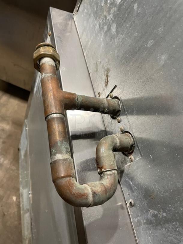 Alt text: Hoshizaki DCM-500BAF ice machine with drip tray, showing rusted pipe attachment on stainless steel exterior.
